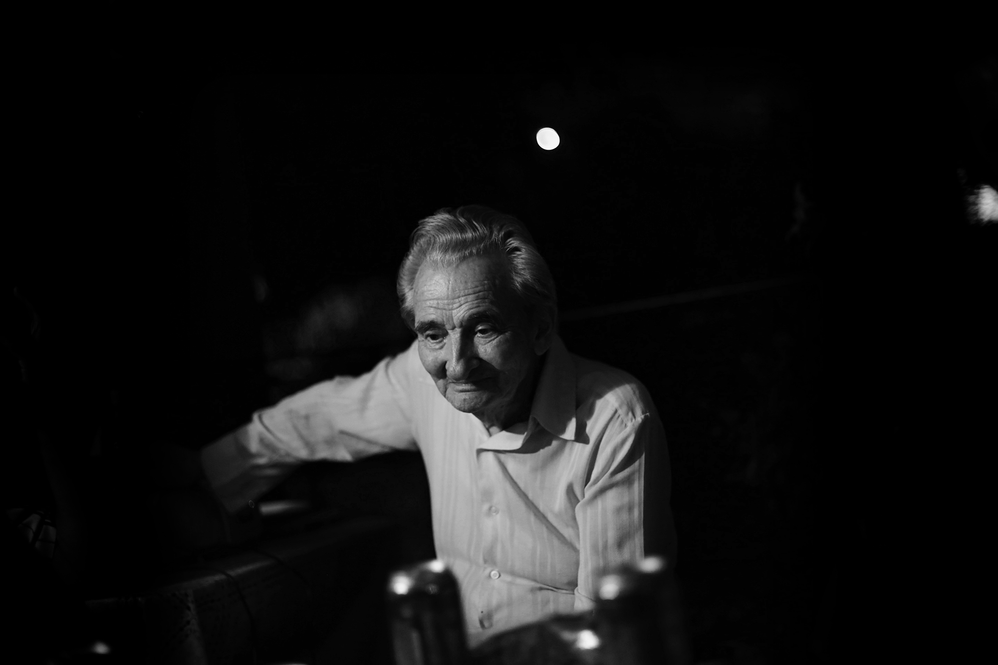 Black and white photograph of Licu, a 92-year-old man staring into space. He is sitting on a chair.